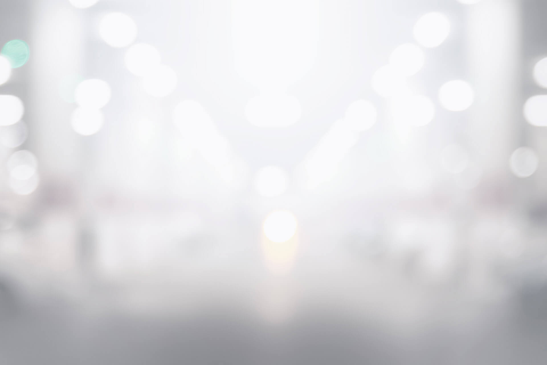 Soft glowing bokeh circles in white and pale gold against a dark blurred background, evoking a bright and celebratory casino atmosphere.